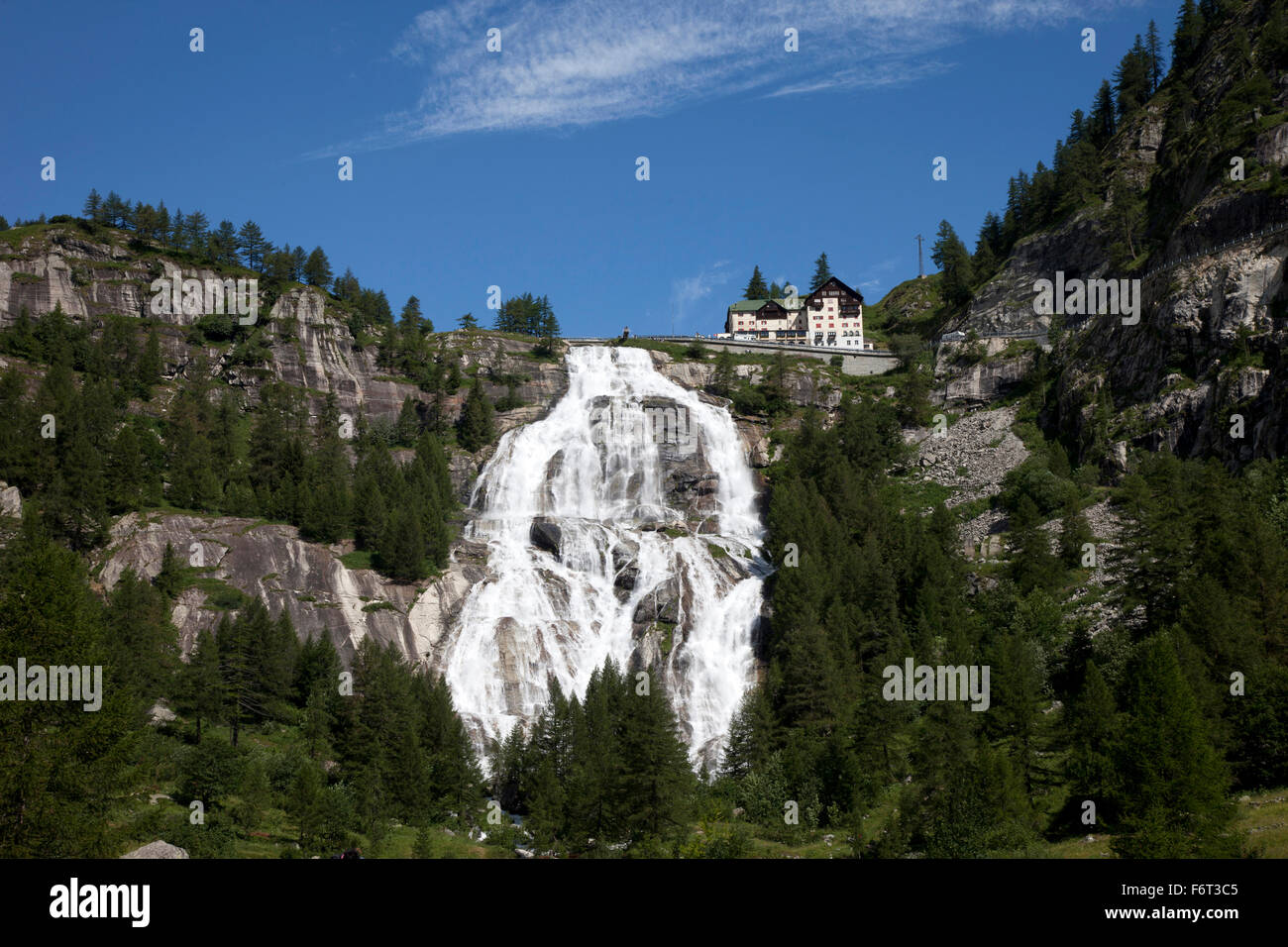 Building over waterfall on remote hillside Stock Photo