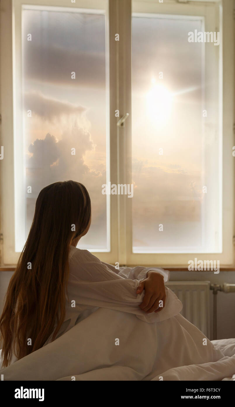 Caucasian woman looking out window Stock Photo