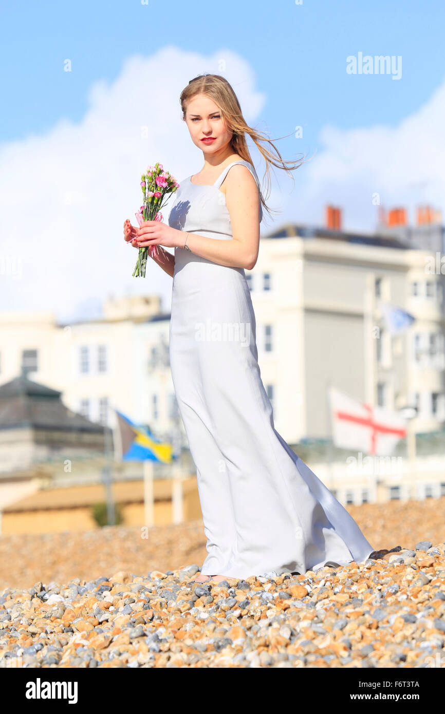 Woman holding bouquet on beach Stock Photo