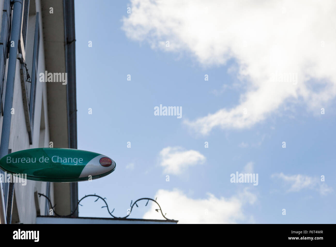 A green and white 'Bureau de Change' sign above a  Post Office. Stock Photo