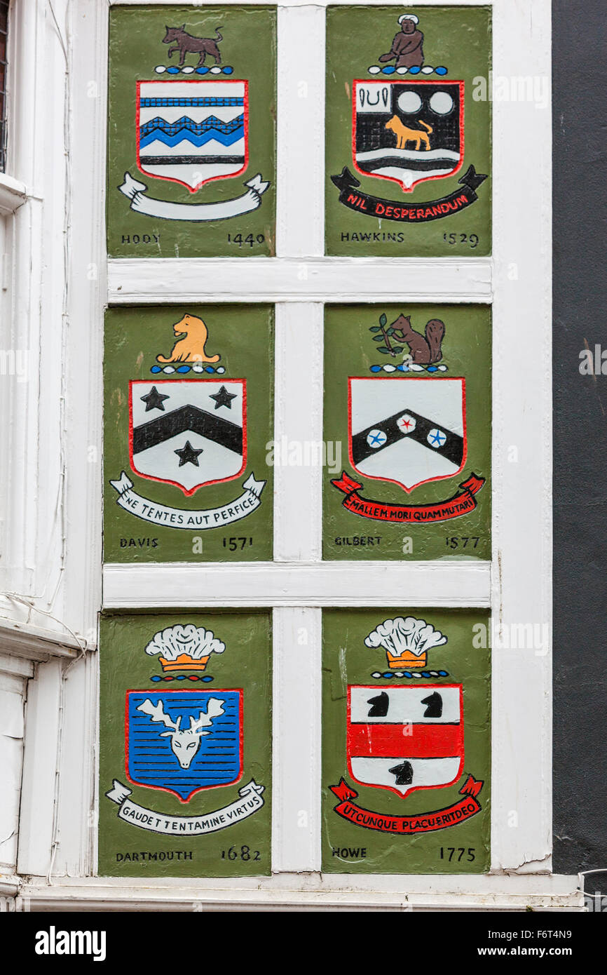 Crests from old local families decorate the upper story of a building in Fairfax Place, Dartmouth, Devon. Stock Photo