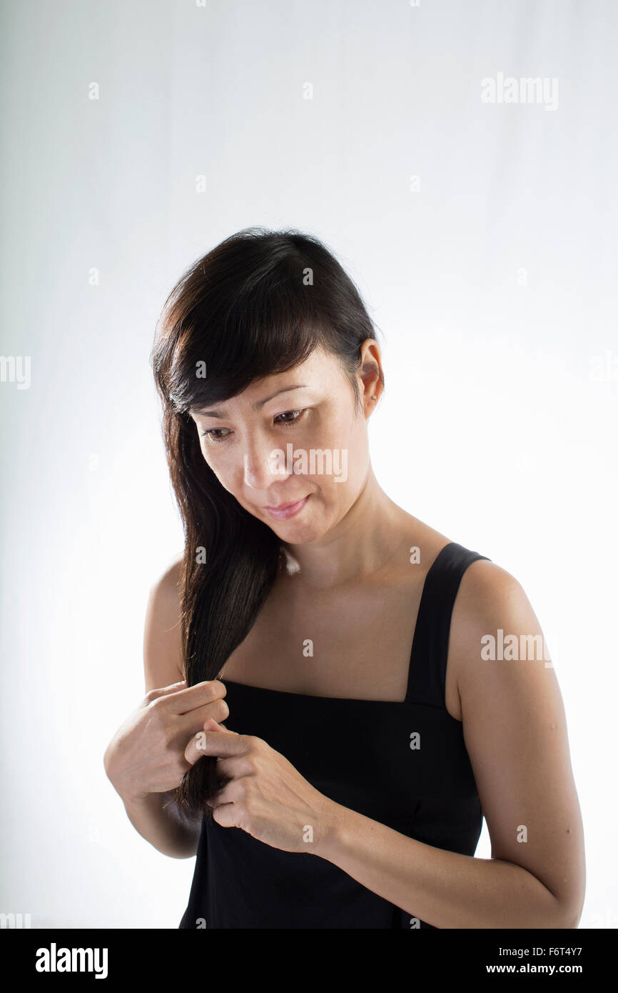 Mixed race woman twisting her hair Stock Photo
