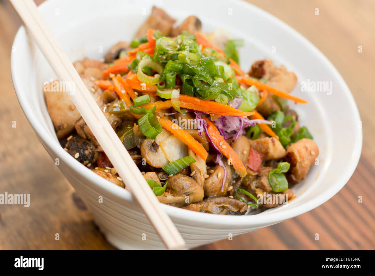 Korean Dak Bulgogi chicken rice bowl topped with fresh scallions Stock