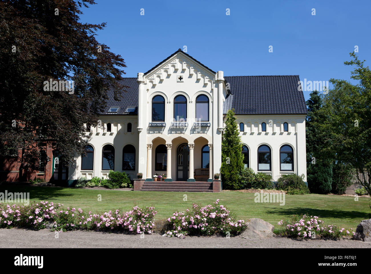 a beautiful big white villa with flowers and trees Stock Photo