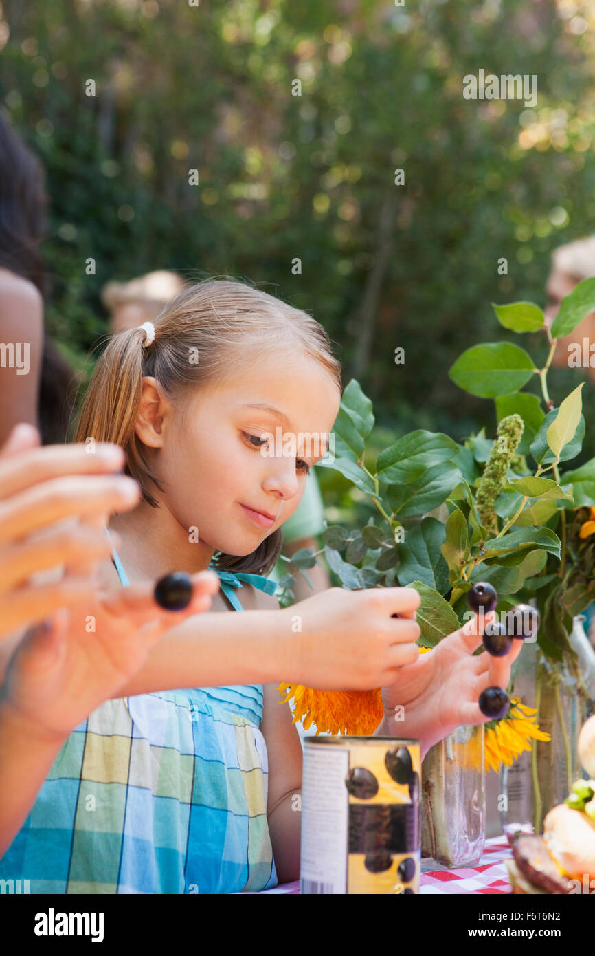 Girl picking flowers and berries in backyard Stock Photo