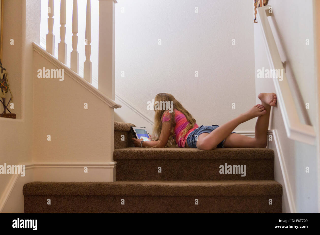 Caucasian girl using digital tablet on stairs Stock Photo