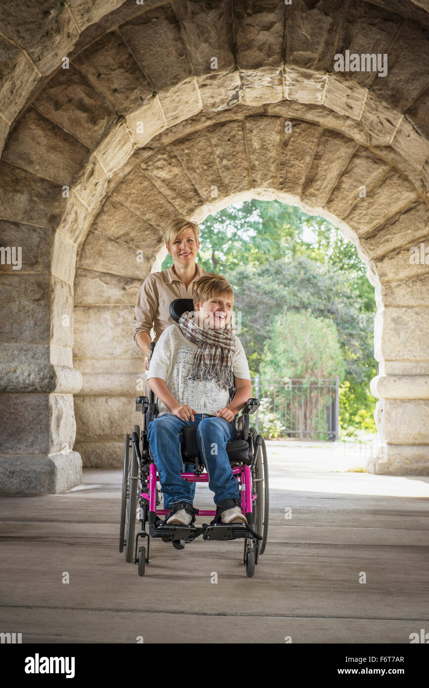 Mother pushing paraplegic daughter in wheelchair Stock Photo