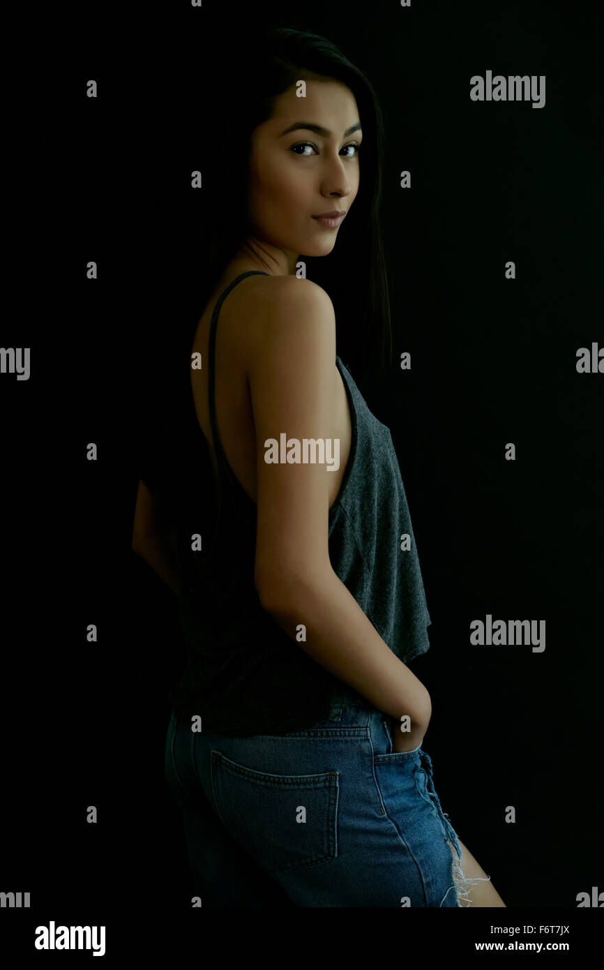 Hispanic woman looking over shoulder Stock Photo