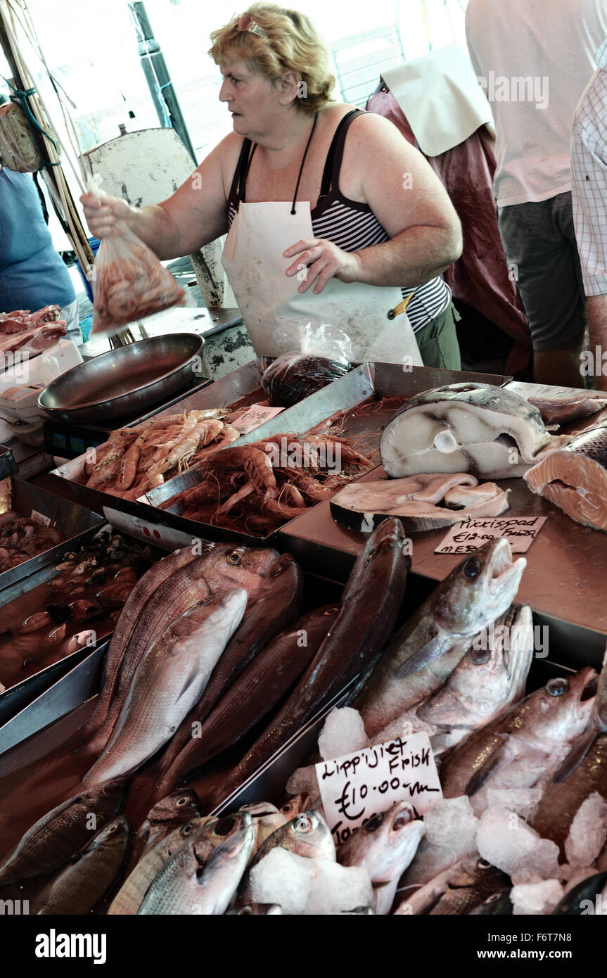 Woman selling shrimps inside a bag at the fish market of Marsaxlokk, Malta Stock Photo