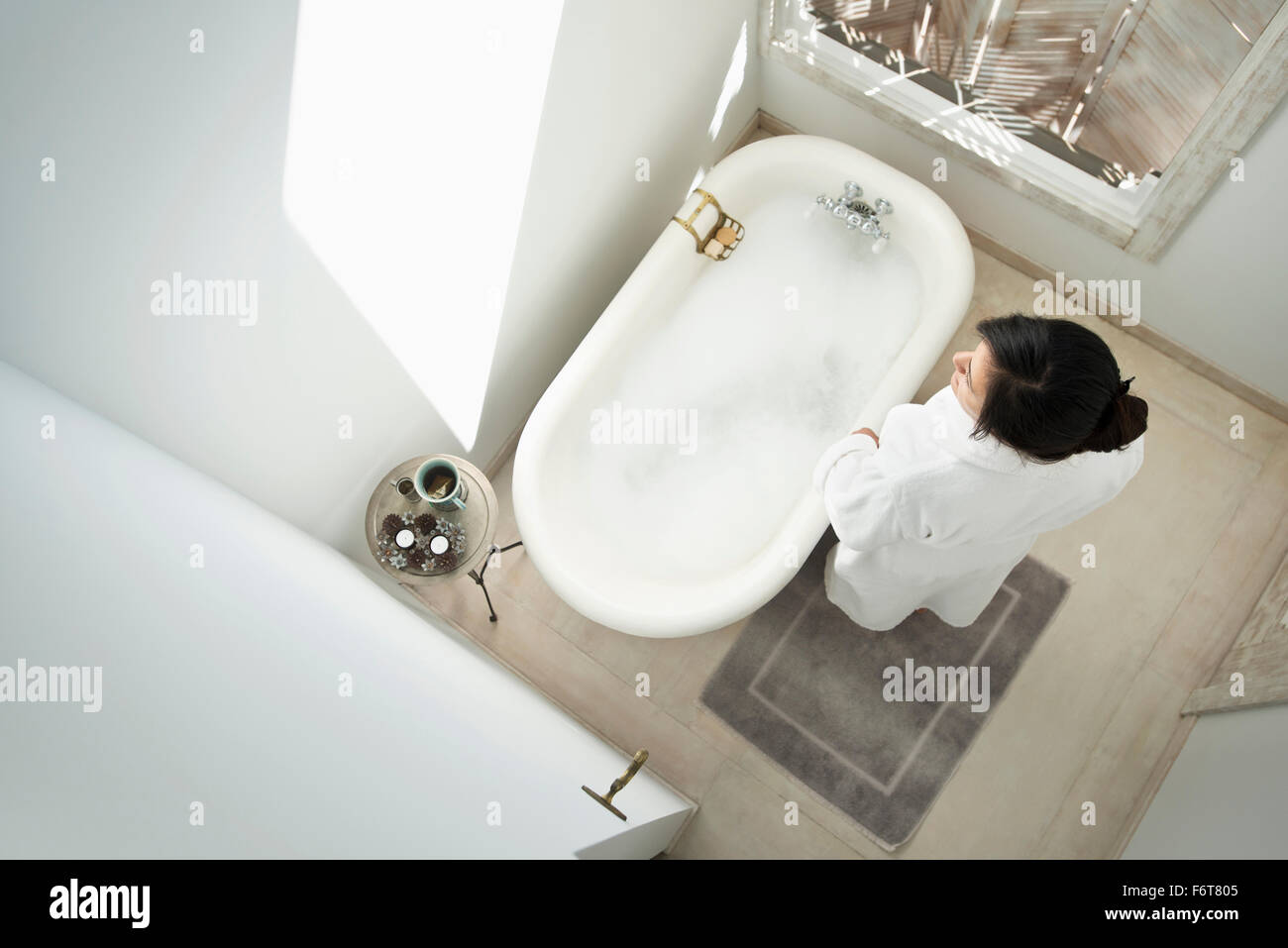 Woman having bubble bath in bathroom Stock Photo