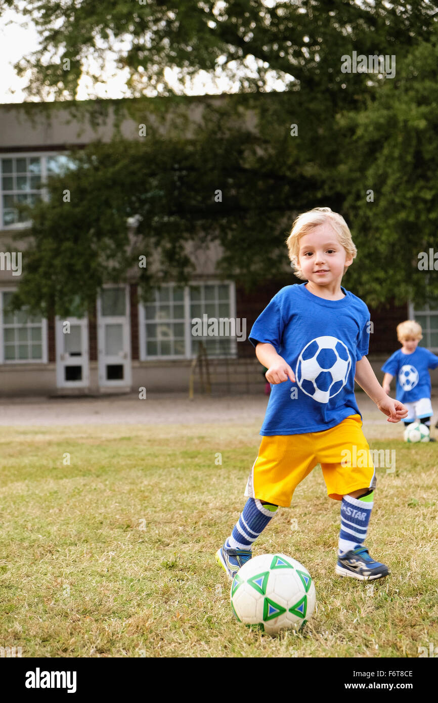 Caucasian boy playing soccer in field Stock Photo