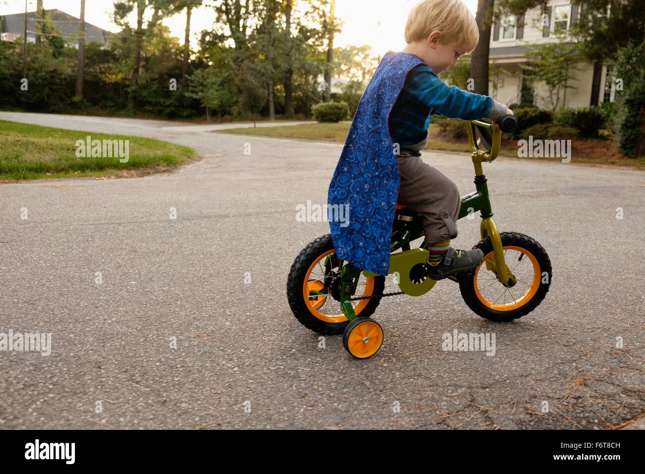 Caucasian boy riding bicycle with training wheels Stock Photo