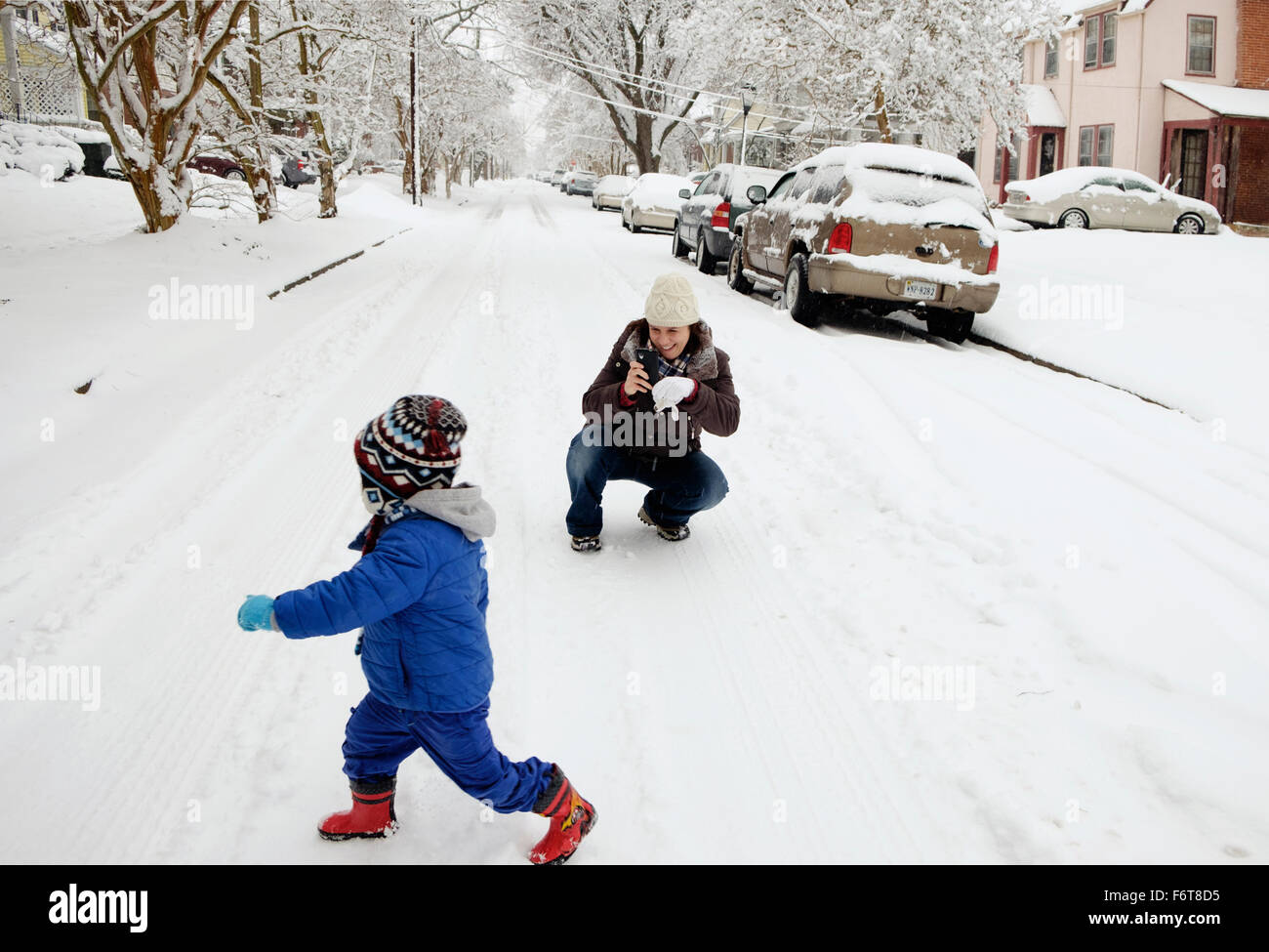 Caucasian mother and son playing in snow Stock Photo