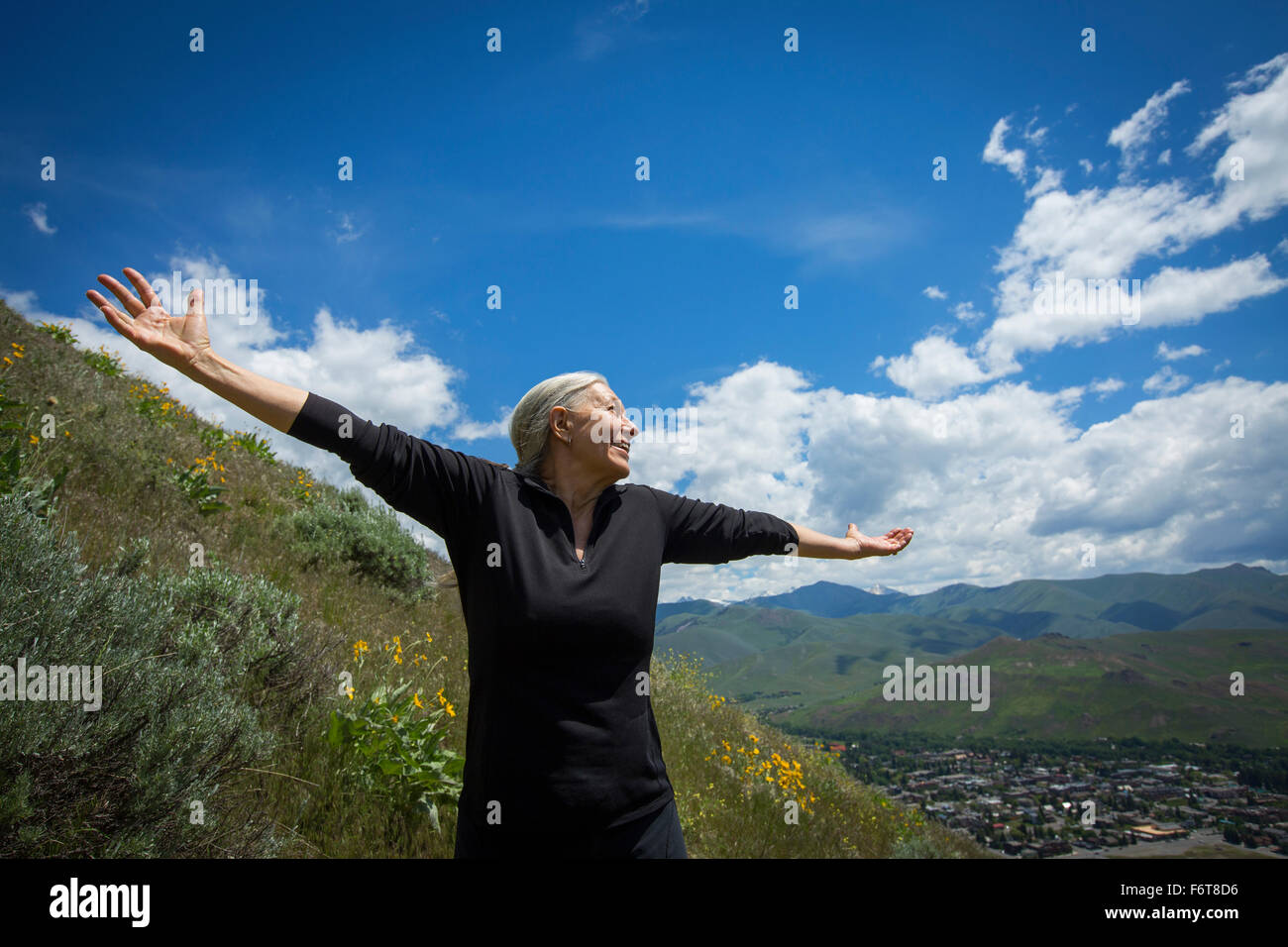 Caucasian woman cheering on rural hillside Stock Photo