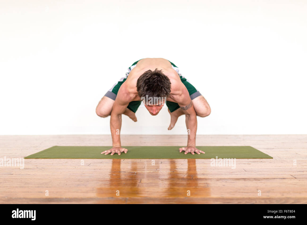 Man practicing yoga in studio Stock Photo