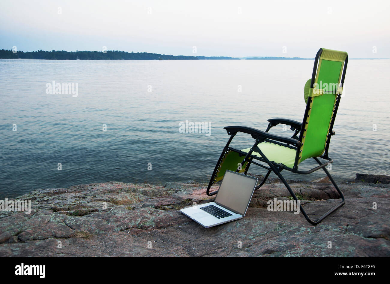 Laptop on lawn chair near remote river Stock Photo - Alamy