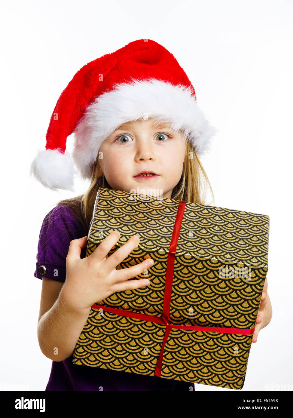 Cute little preschooler girl in red santa hat with gift box isolated on ...