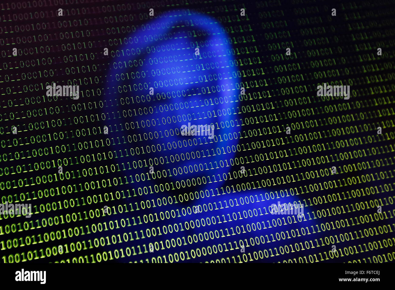 A face is reflected into a computer screen with binary type Stock Photo