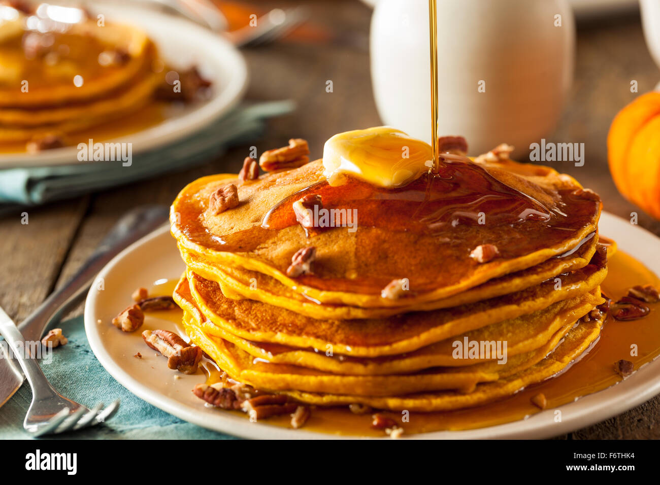 Homemade Pumpkin Pancakes with Butter Pecans and Maple Syrup Stock Photo