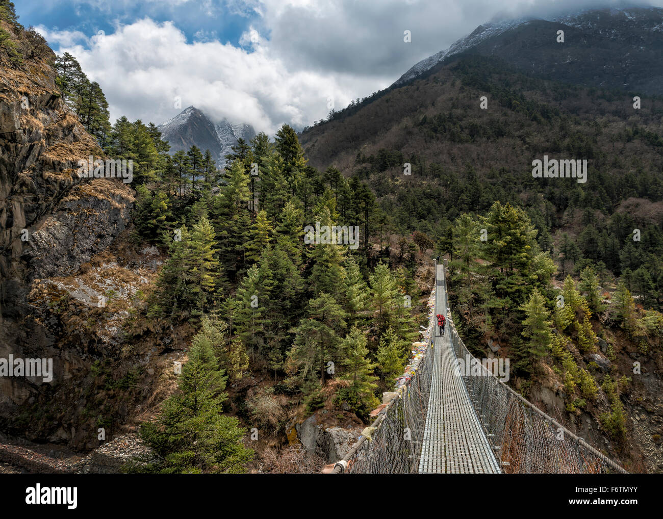 Nepal, Himalaya, Khumbu, trekker on footbridge in the mountains Stock Photo