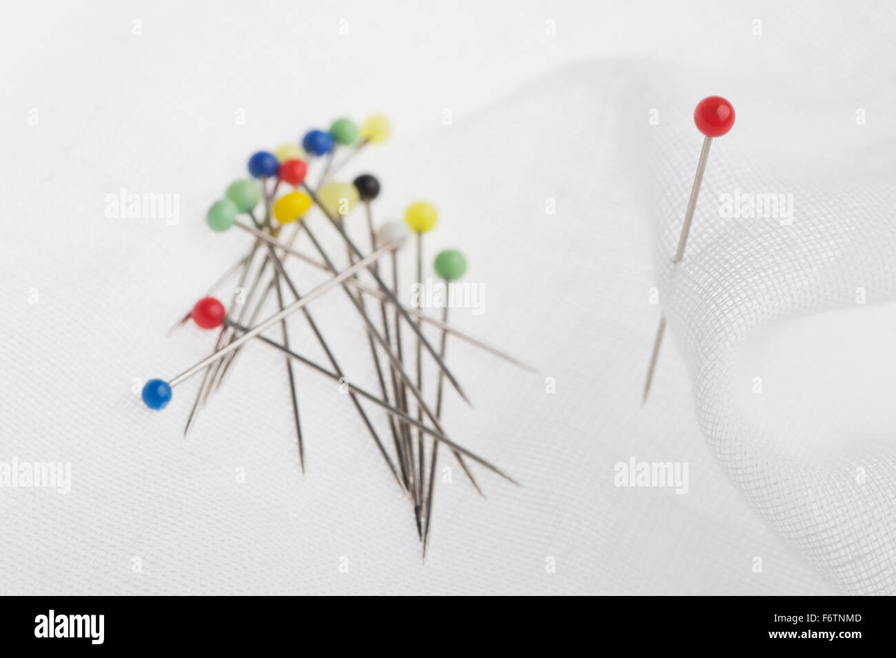 Colorful pins, white cloth Stock Photo - Alamy