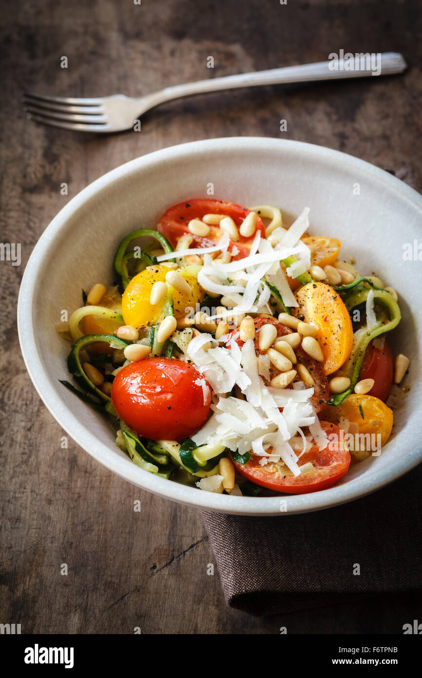 Helically coiled courgette, vegetable noodles, tomato and parmesan in ...