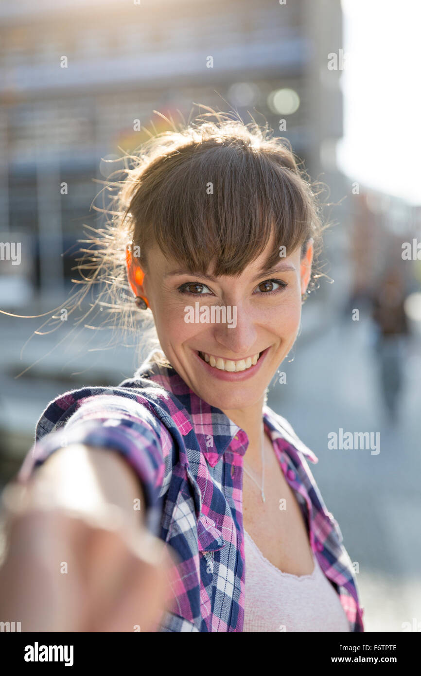 Portrait of smiling young woman holding hands Stock Photo - Alamy