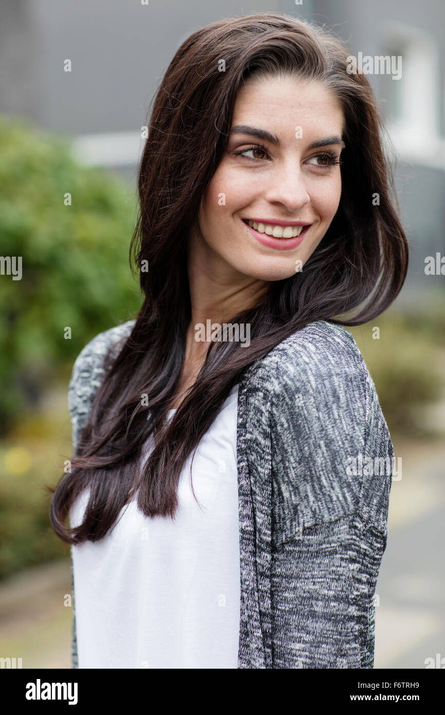 Portrait of smiling young woman with long brown hair Stock Photo - Alamy