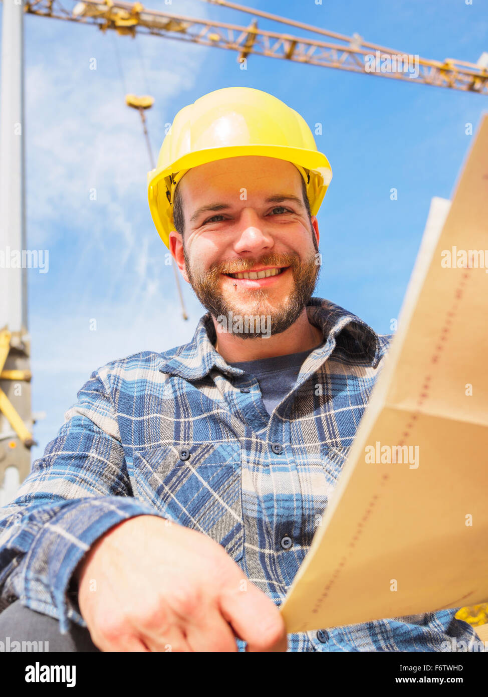 Portrait of smiling foreman with construction plan Stock Photo