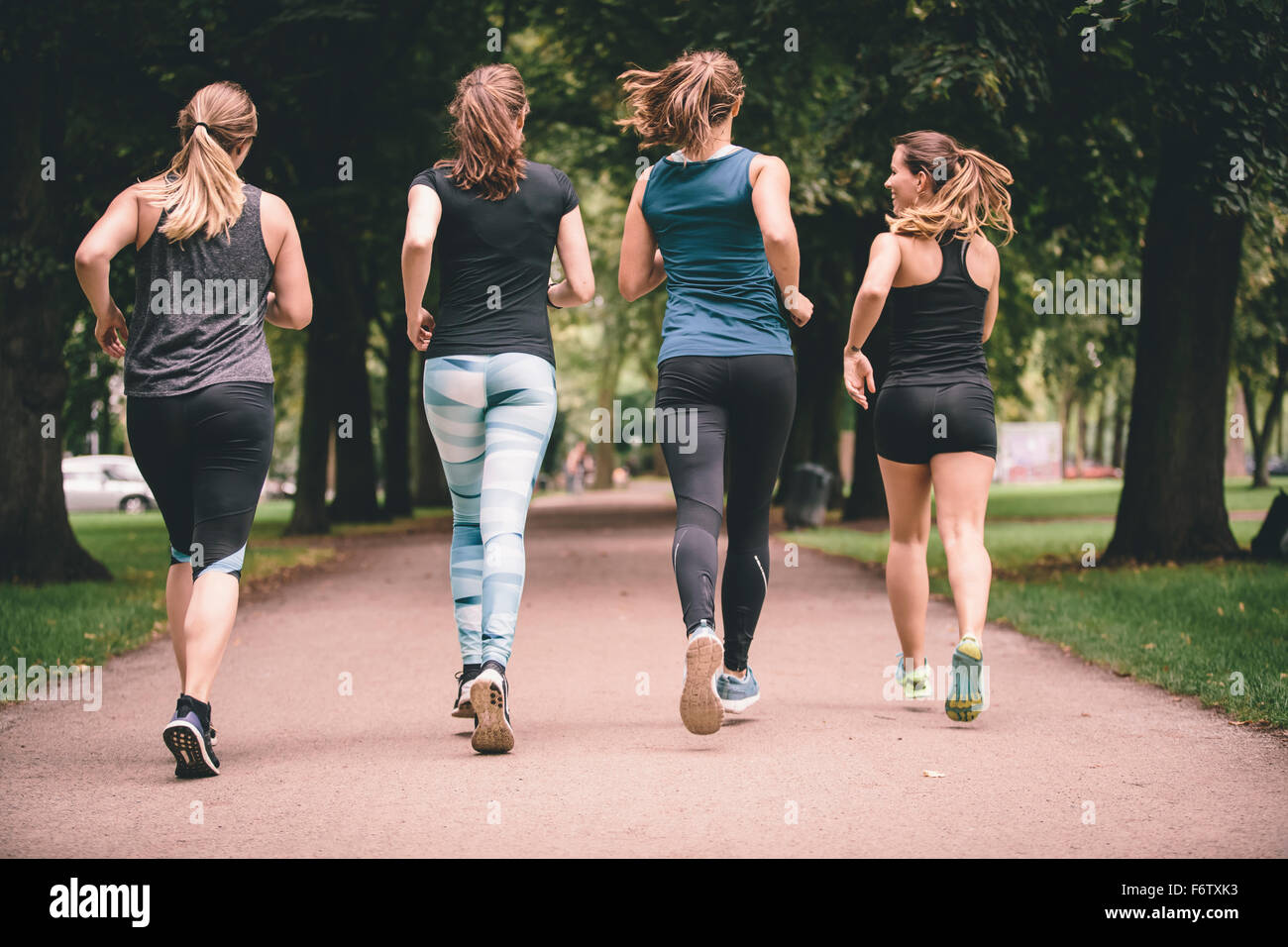 Four women jogging in park Stock Photo