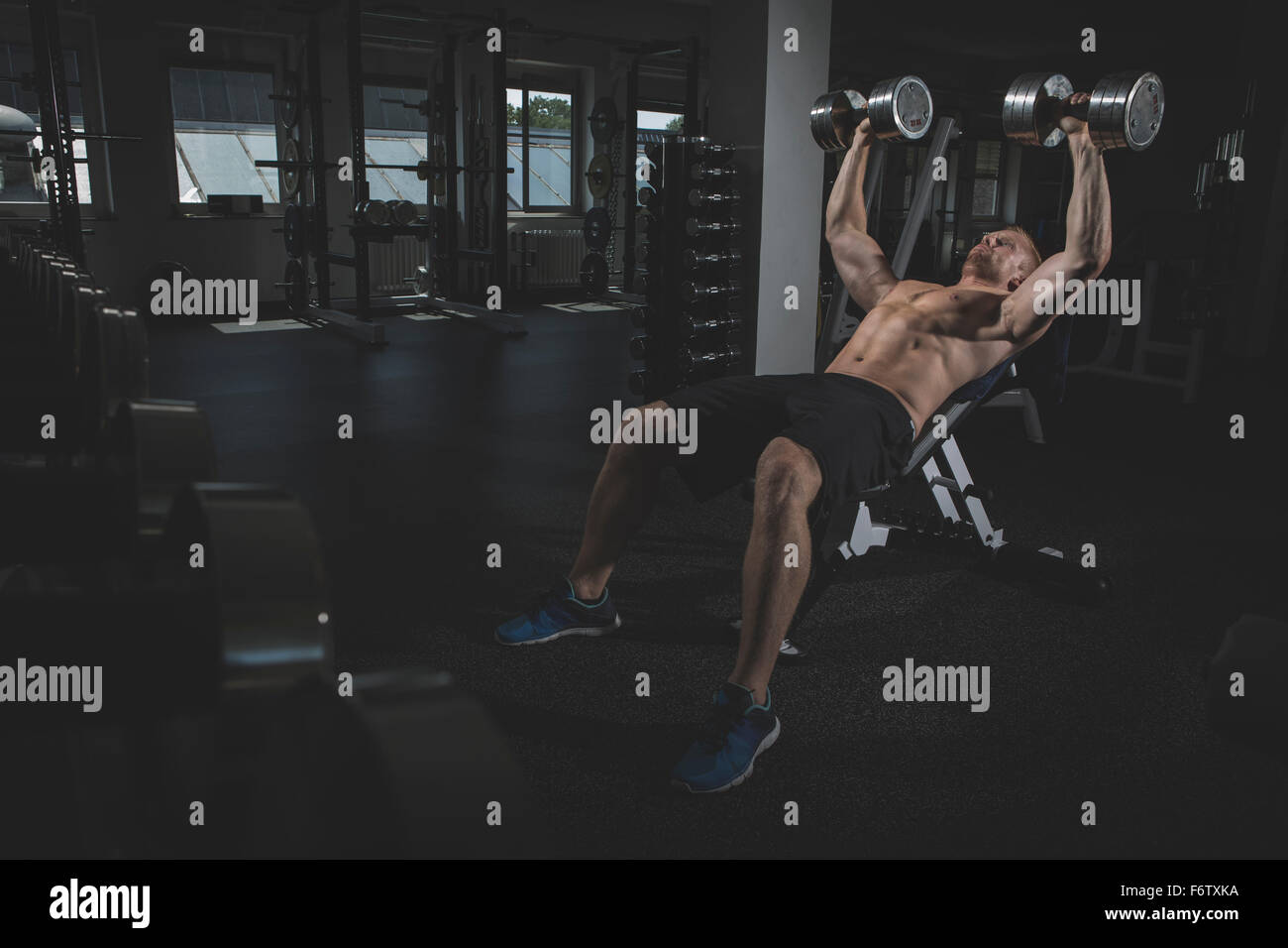Physical athlete doing bench presses with dumbbells Stock Photo Alamy