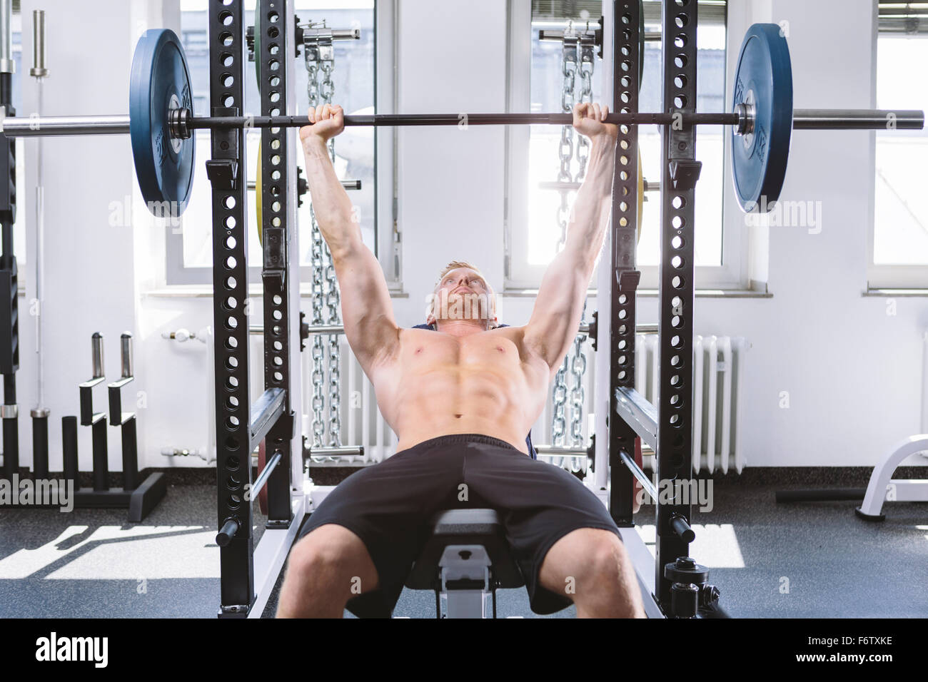 Physical athlete doing bench presses Stock Photo