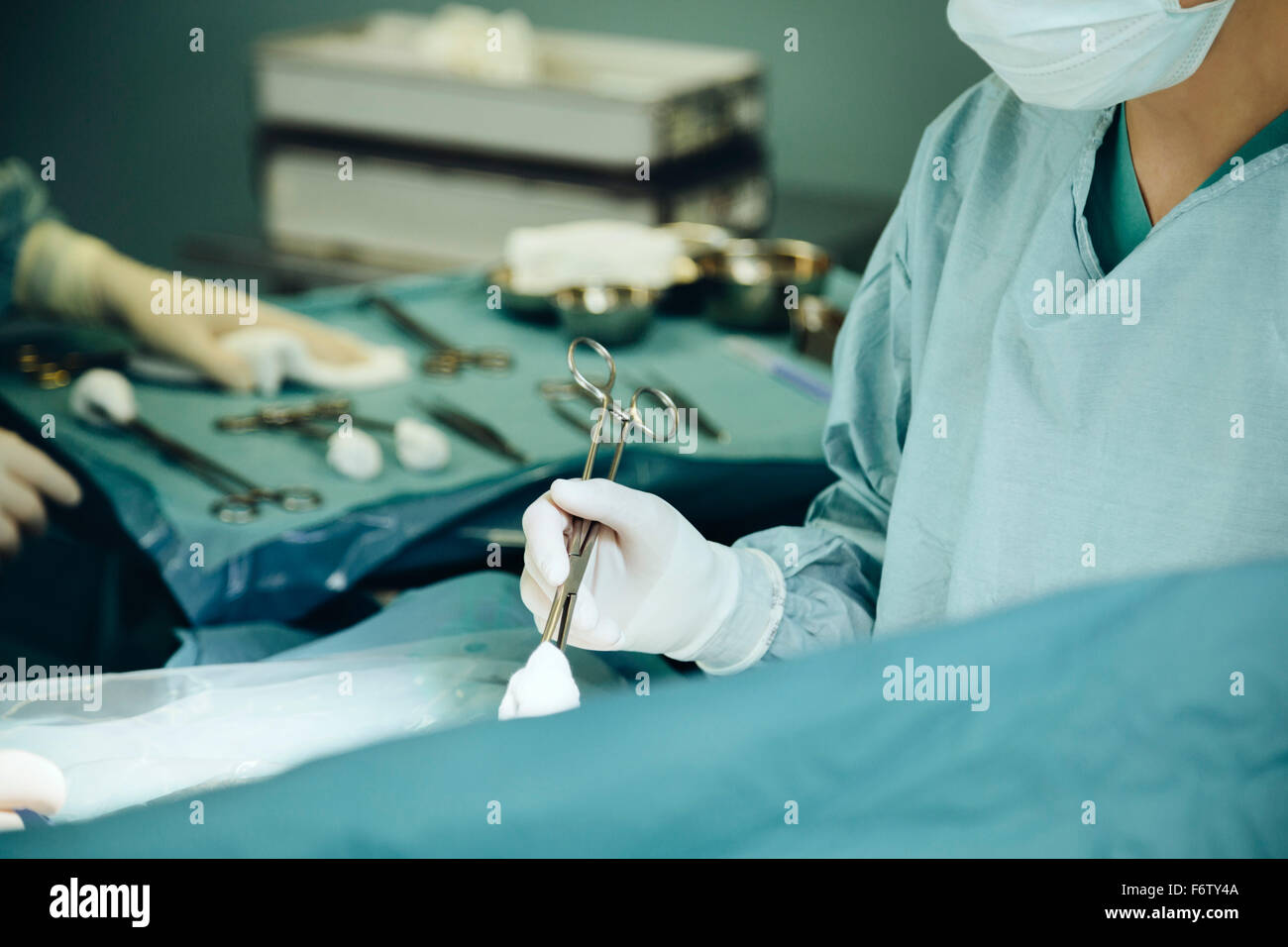 Surgeon holding clamp in operating room during surgery Stock Photo Alamy