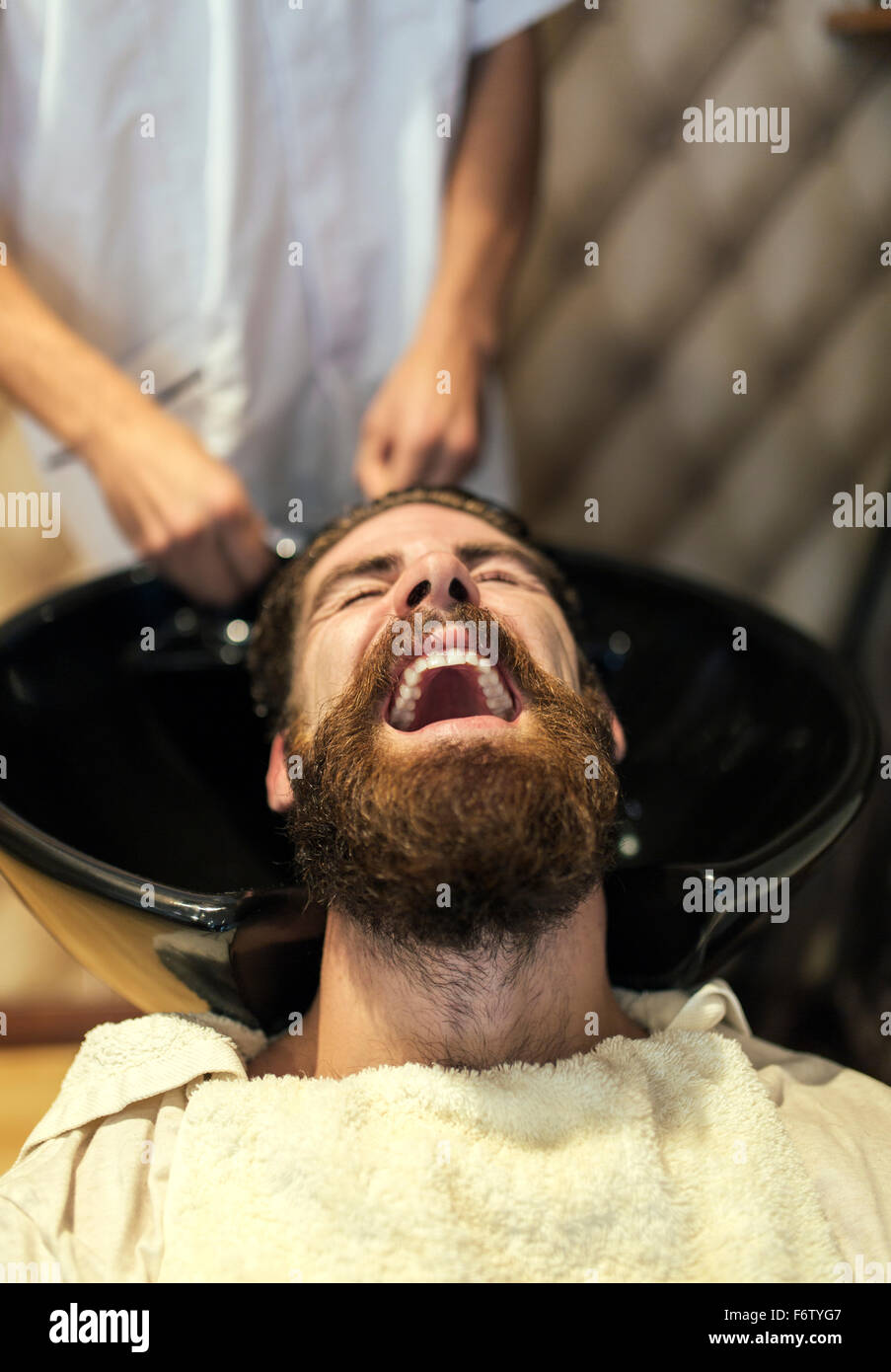 Barber washing hair of a customer with open mouth Stock Photo Alamy