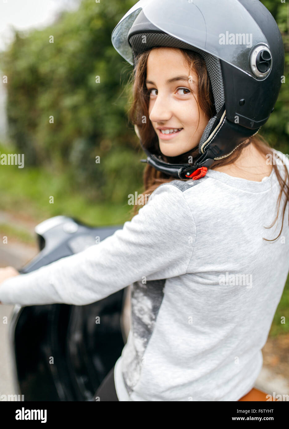 Portrait of smiling girl wearing motorcycle helmet sitting on a Vespa Stock  Photo - Alamy