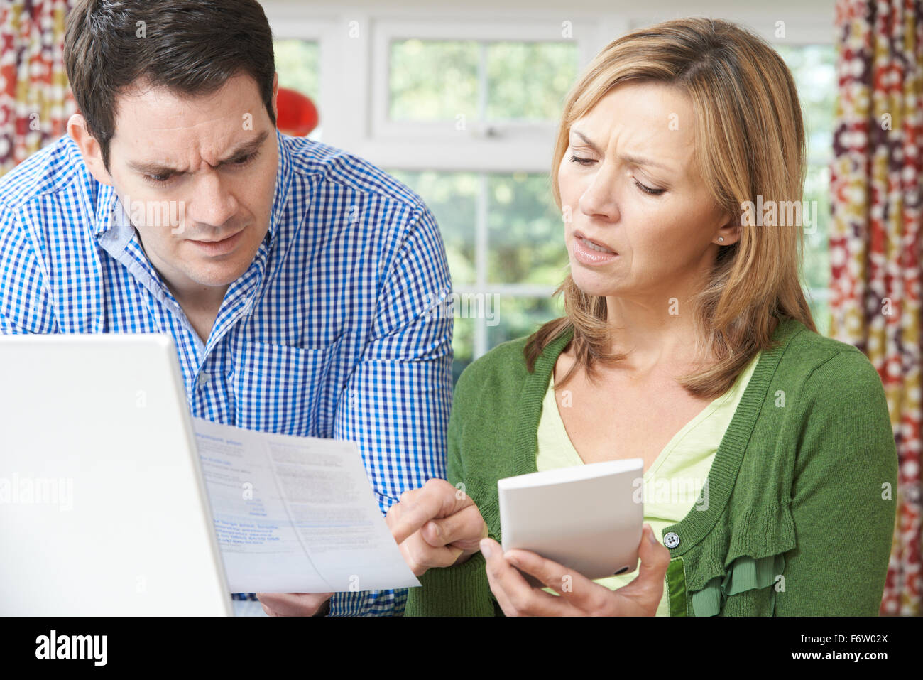 Worried Couple Discussing Domestic Finances At Home Stock Photo