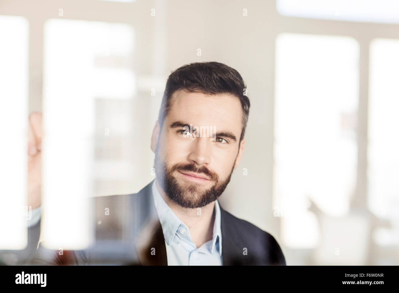 Portrait of businessman behind glass wall Stock Photo