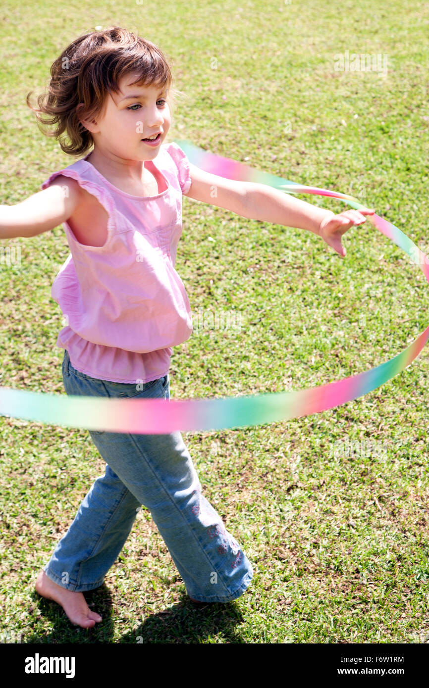 Little girl playing with hulahoop in the garden Stock Photo Alamy