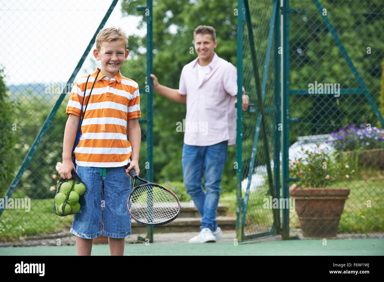 Father Dropping Son Off For Tennis Lesson Stock Photo