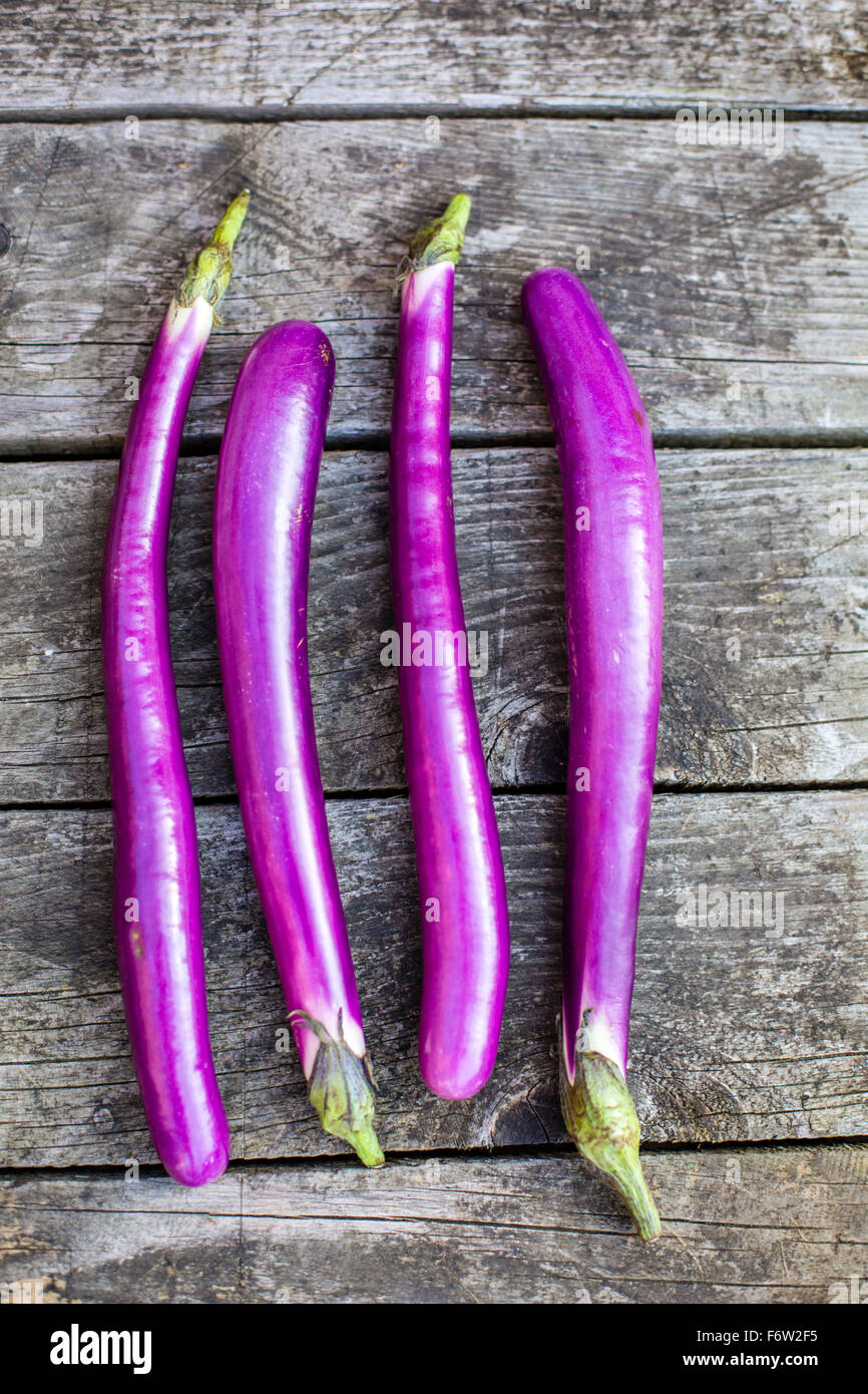 Thin aubergines on wood Stock Photo