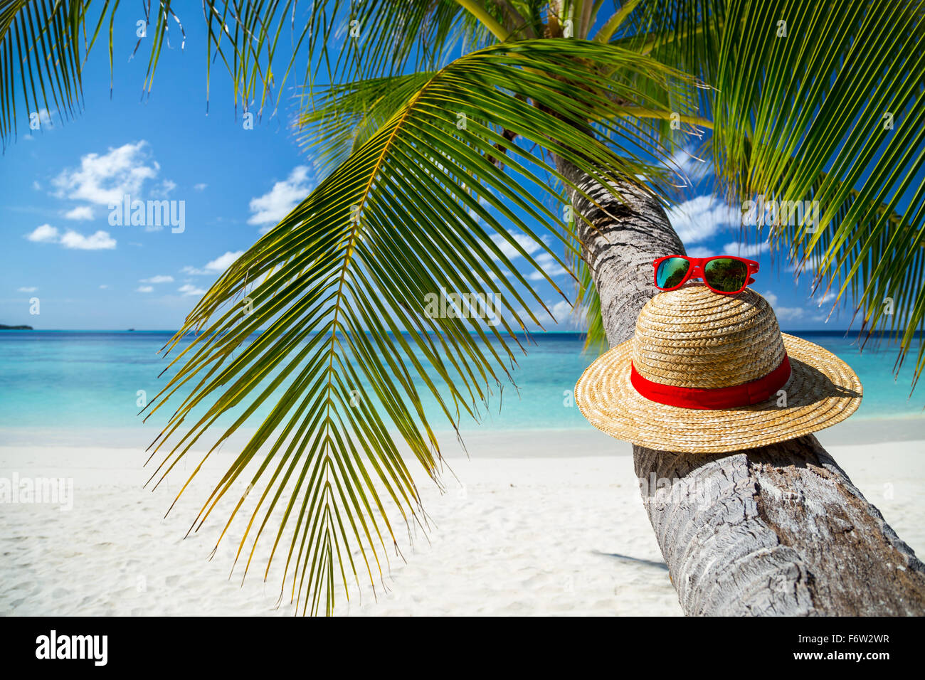 straw hat with sunglasses in front of paradise beach Stock Photo