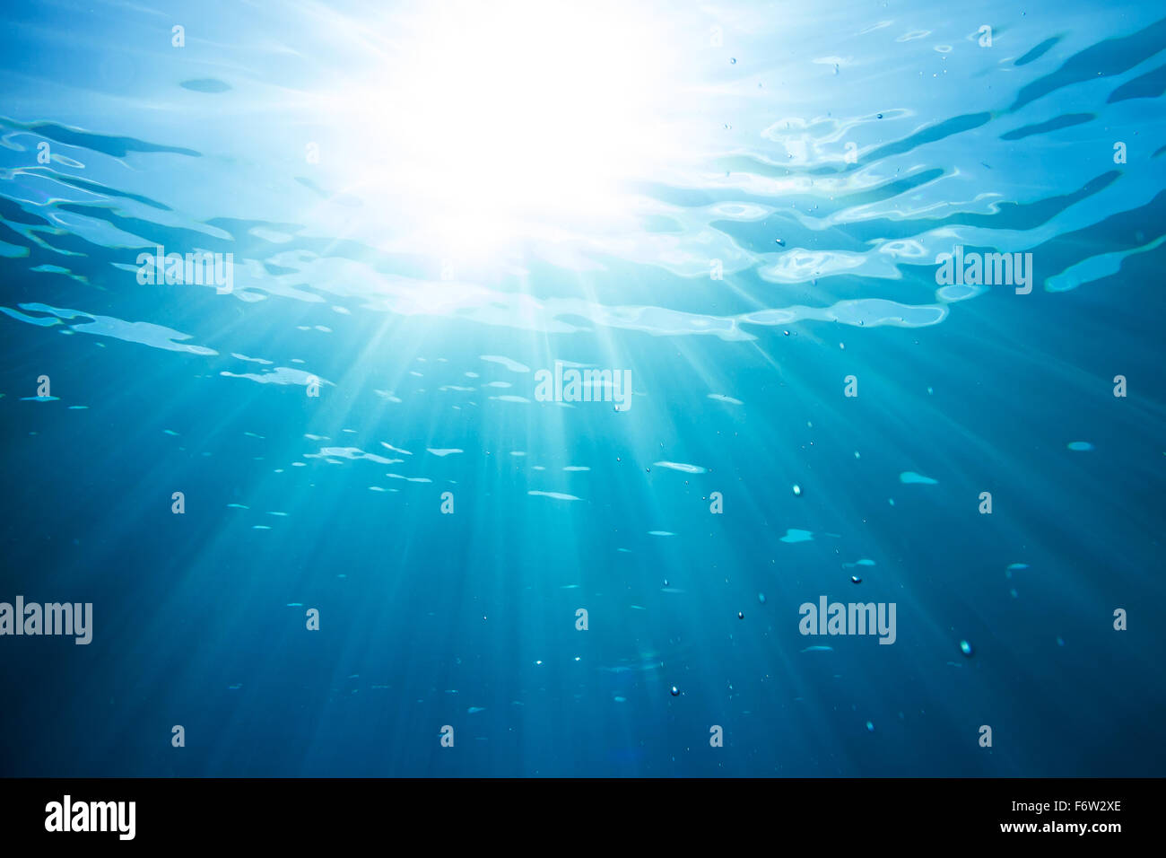 sun and sunbeams underwater shining through the surface Stock Photo