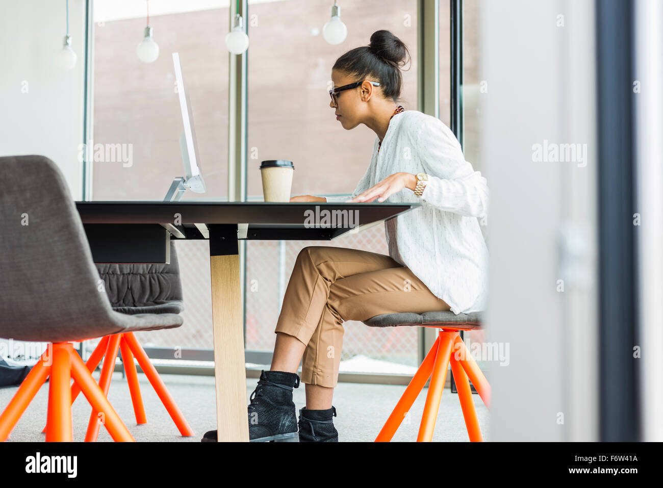 Young woman in office working on computer Stock Photo