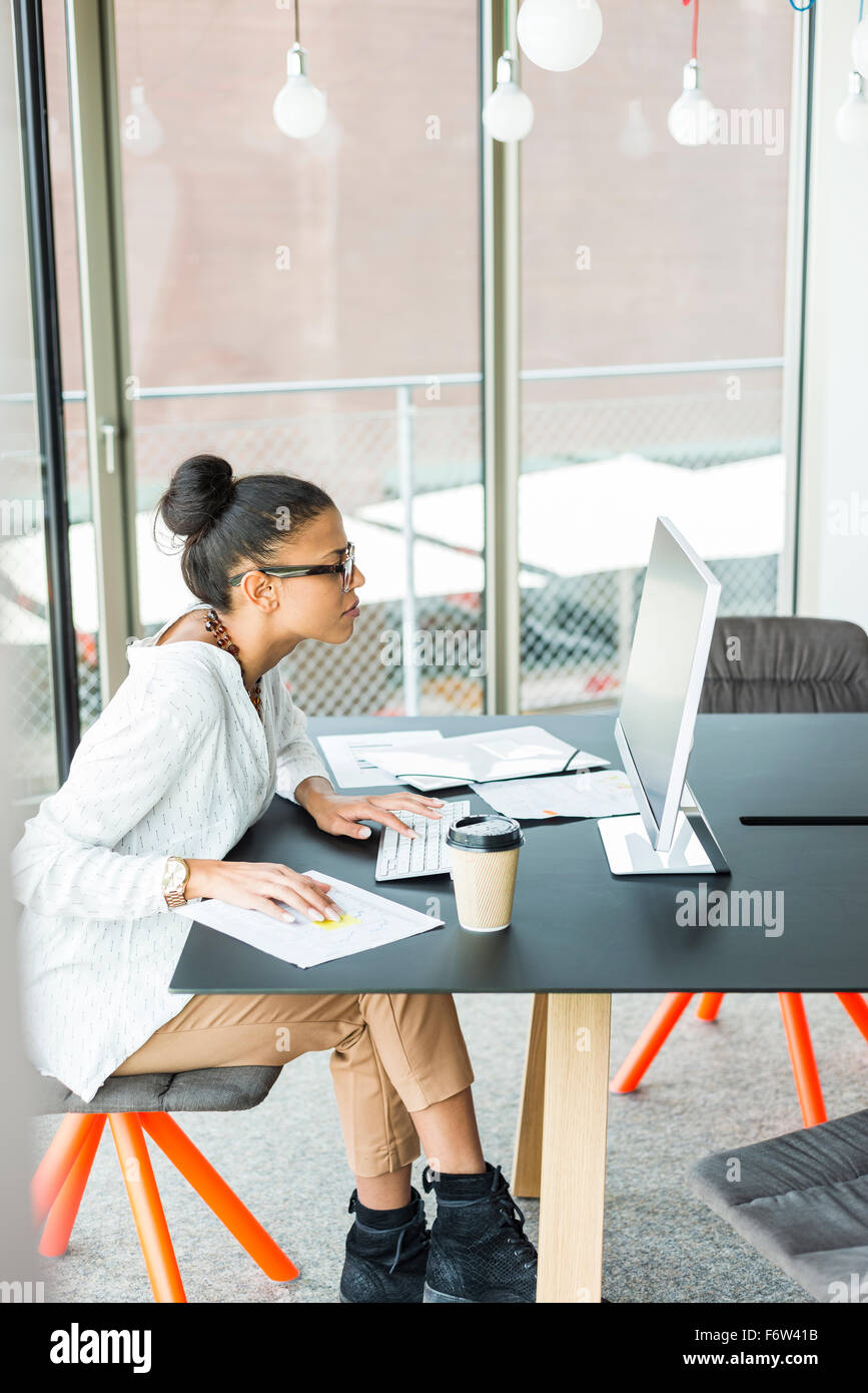 Young woman in office working on computer Stock Photo - Alamy