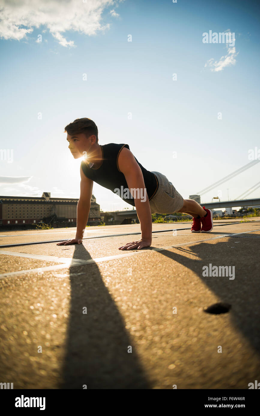 Young man doing push-ups outdoors Stock Photo - Alamy