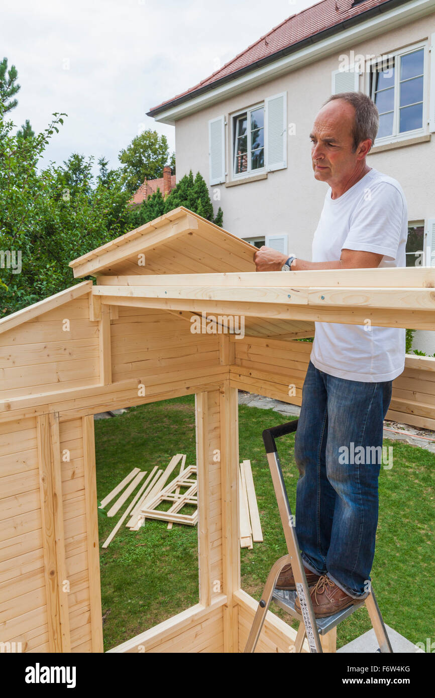 Man setting up a garden shed Stock Photo