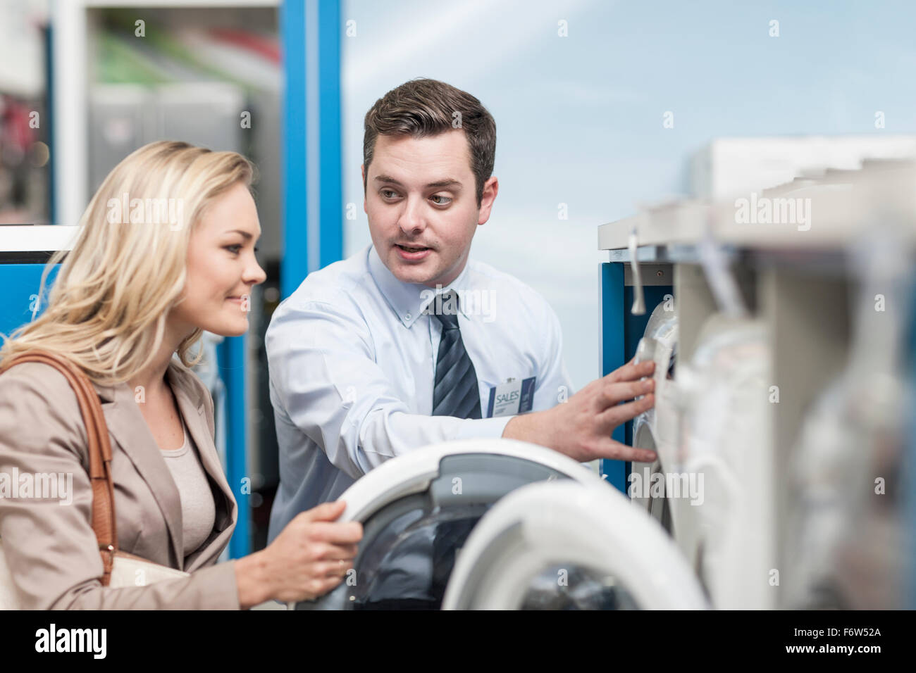 Shop assistant explaining washing machine to customer Stock Photo Alamy