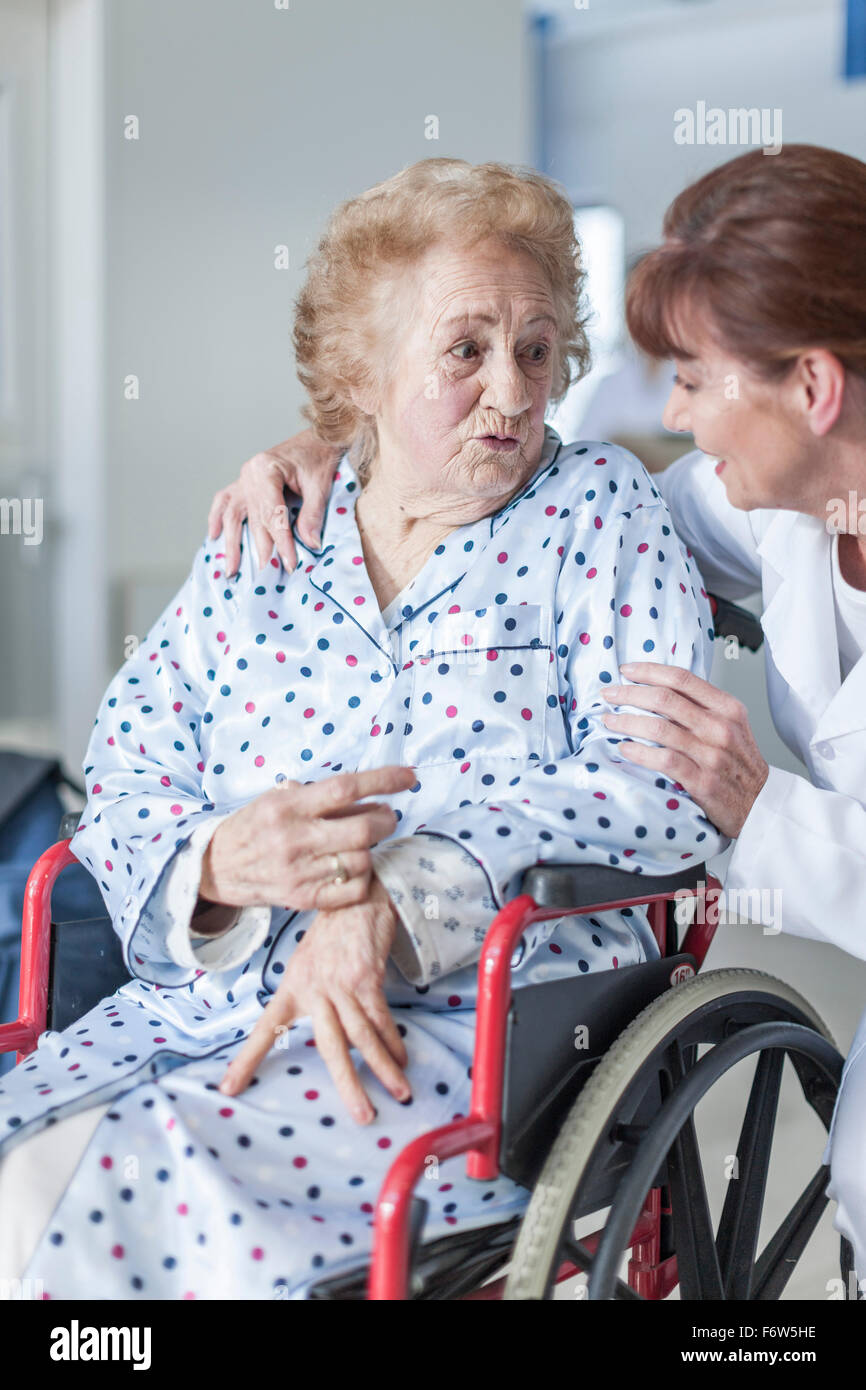 Doctor caring for elderly patient in wheelchair Stock Photo Alamy