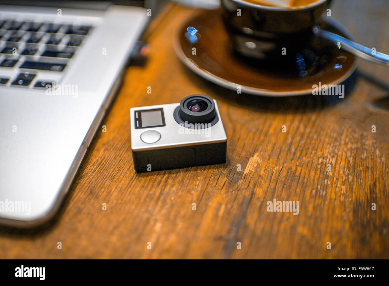 Small action video camera with coffe cup and laptop on the wooden table Stock Photo