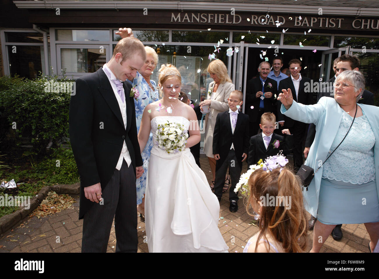 Guests throwing confetti over bride and groom outside church Stock Photo Alamy